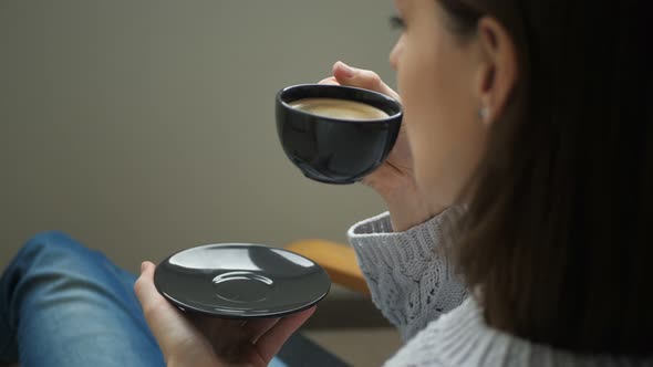 Woman Drinking Coffee in the Morning Sitting in a Chair