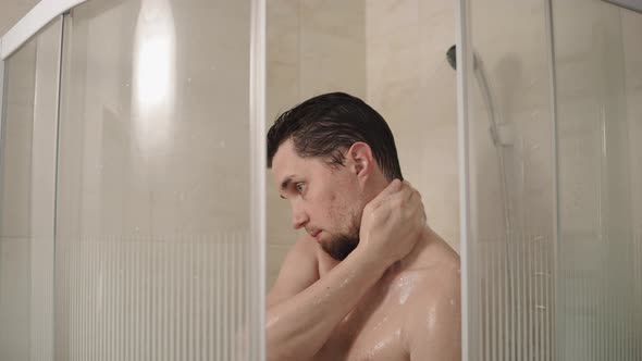 Slim Man Is Lathering His Body with Soap in a Shower, Portrait