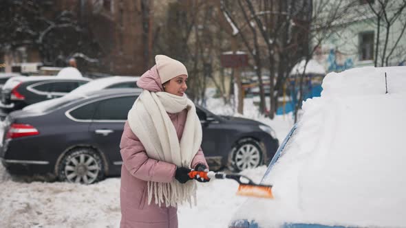 Woman Removing Snow From Car