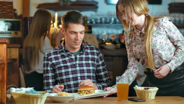 Attractive Man Getting His Burger Order in Cafe