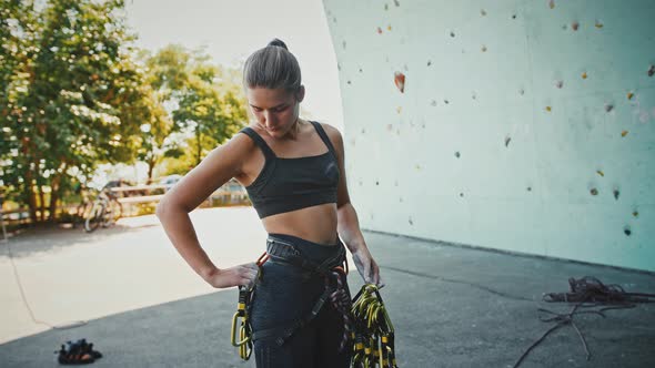 Young Woman Hanging Carbines on Her Belaying Harness Outdoors Tracking Shot
