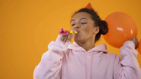 Cheerful Girl With Birthday Whistle and Balloons Having Fun Enjoying Party