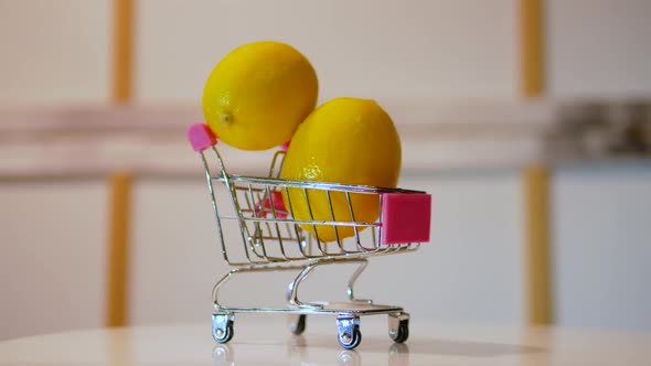 Yellow Ripe Lemons In Peel In A Grocery Cart. Lemons Are Spinning On The Table In A Cart