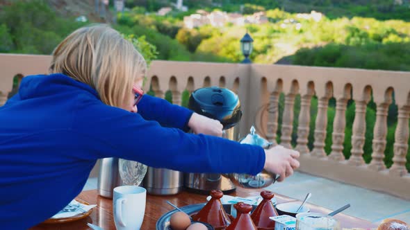 Blonde tourist girl having typical moroccan breakfast in High Atlas mountains