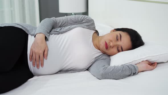 pregnant woman sleeping on a bed