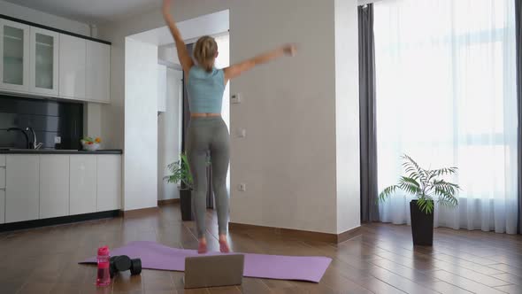 Woman Dancing at Home During Online Training on Laptop