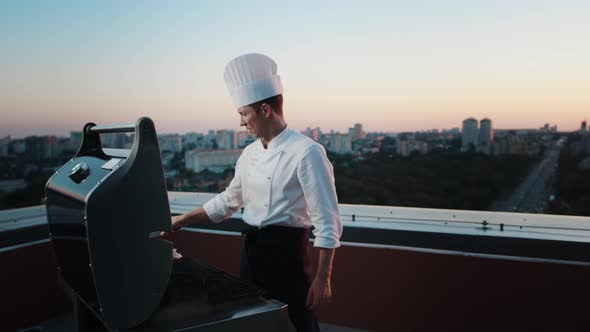 A professional Chef prepares a barbecue on the rooftop of a skyscraper. An expensive restaurant