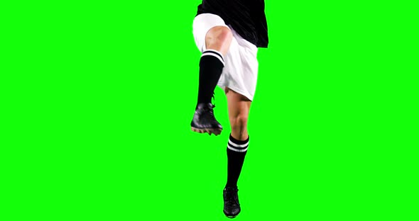 Athlete practicing soccer against green screen