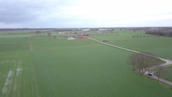 Aerial View of a Field with a Winding Asphalt Country Road Shot with a Drone