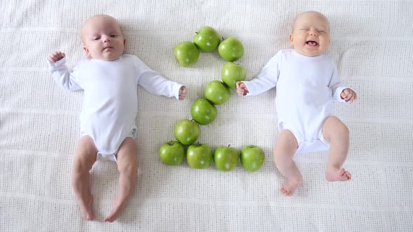 Cute Twin Two Months Babies In White Bodysuites