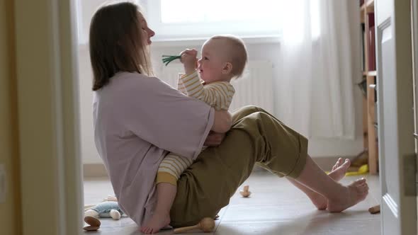 Little Baby Girl and Mommy Playing at Home Sitting on Floor