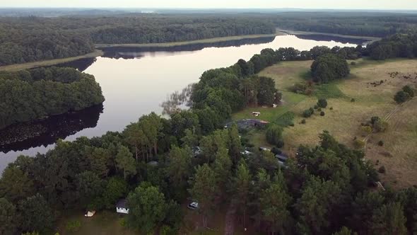 Unbelievable aerial flight rising up drone shot overview lake in summer morningin nature reserve Mü