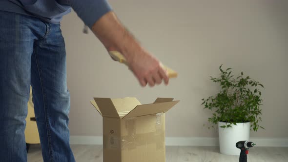 Man Unpacks Cardboard Box Takes Out Pieces of Wooden Furniture