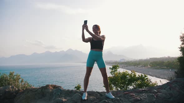 Sportive Woman Taking a Selfie on the Hill By the Sea