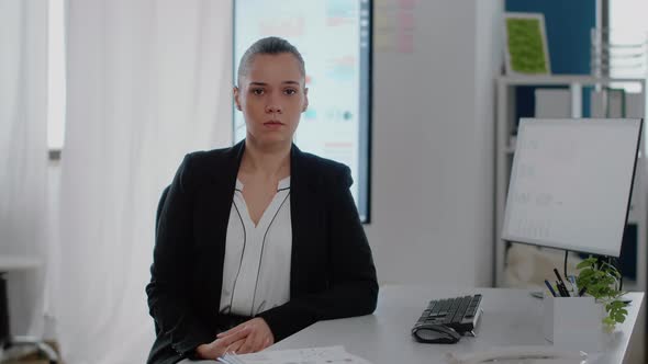 Portrait of Businesswoman with Office Job Sitting at Desk