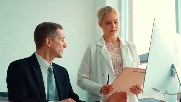 Two Business People Talk Project Strategy at Office