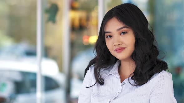 Medium Closeup Shot Portrait of Smiling Asian Young Business Woman Looking at Camera