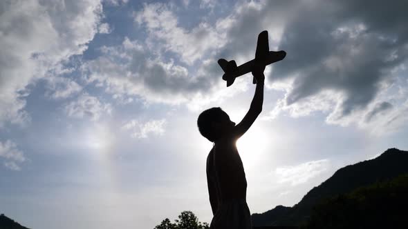 Silhouette Kid Playing With Toy Airplane 