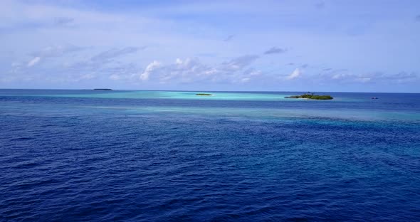 Natural overhead tourism shot of a summer white paradise sand beach and blue water background in 4K