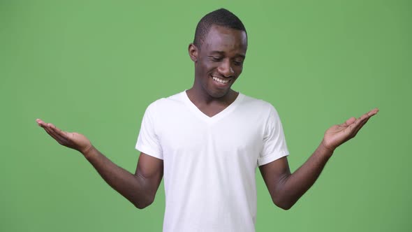 Young African Man Smiling While Choosing Between Left and Right