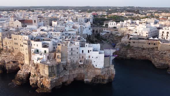 Aerial circling shot of coast of Polignano a Mare at sunset. Italy