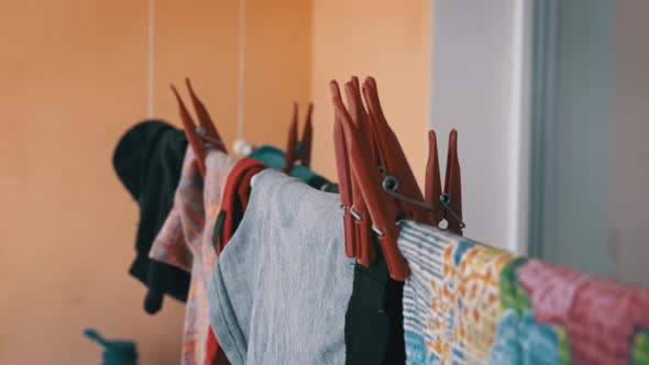 Laundry are Dried on a Rope with Red Clothespins Under the Rays of the Sun