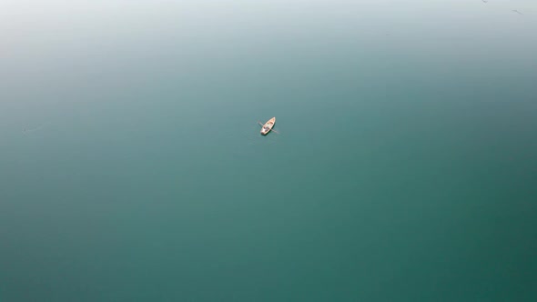 Aerial View Lone Wooden Boat in the Middle of Water Surface of a Mountain Lake