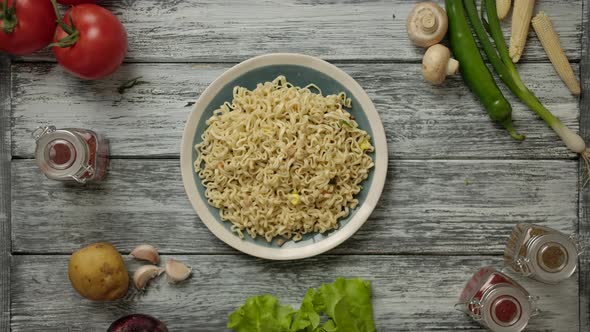 Hands Put Chinese Chopsticks on a Plate of Noodles.