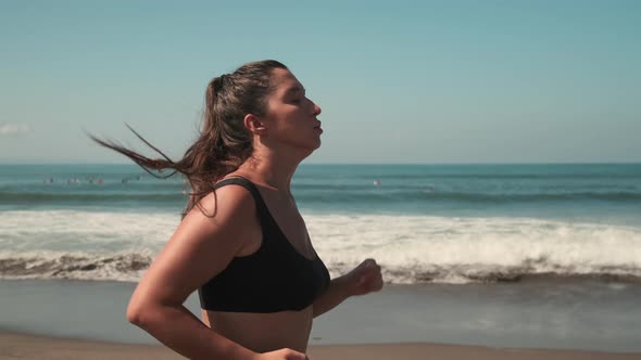 Attractive Woman Jogging Along Golden Seacoast