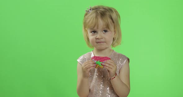 Girl in Glossy Dress Begins To Eat Cookies in the Form of Strawberries