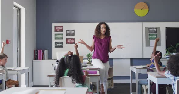 Video of caucasian female teacher and diverse school children studying in classroom