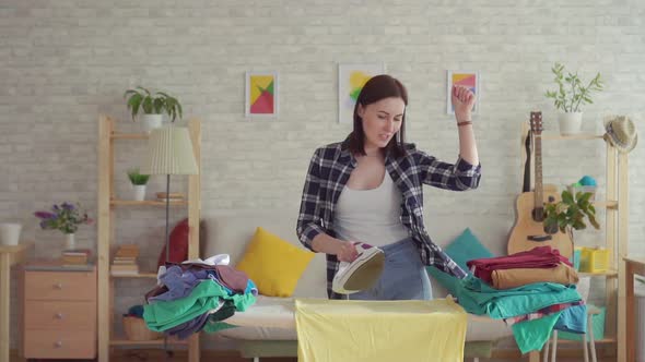 Cheerful Young Woman in Plaid Shirt Ironed Linen Iron at Home Dancing Close Up