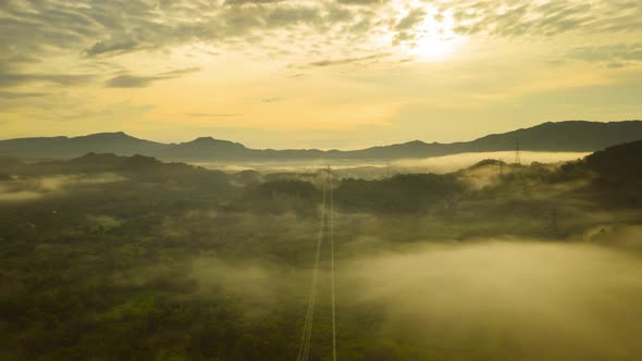 Aerial views, mountains and clouds with High-voltage power pole,