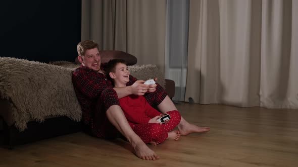 Active Dad Playing Video Game Console with Son