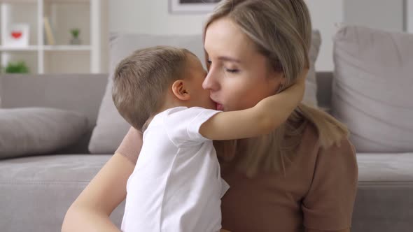 Happy Young Mum Hugging Kid Son Soothing Little Boy at Home