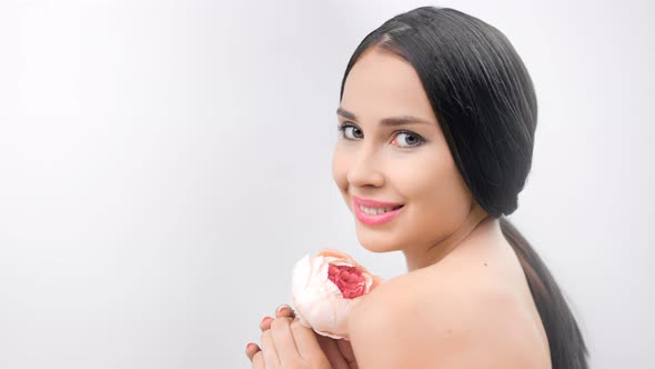 Beautiful Seductive Young Woman Smiling Posing with Gentle Pink Flower Isolated at White Studio