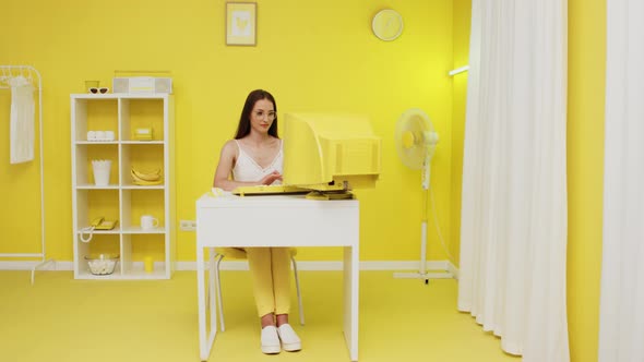 Young Woman Is Working at Old Yellow PC