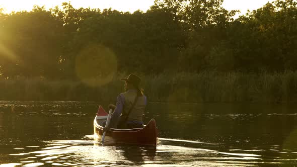 Cowboy in a Canoe Floats on the River