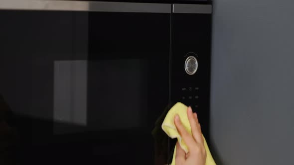 Woman Hands Warming Up a Container of Food in the Modern Microwave Oven for Snack Lunch at Home