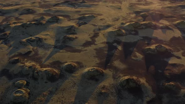 Drone Shot of Rocky Lands with Large Shadows Being Casted Upon Against the Sun