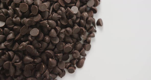 Video of close up of multiple chocolate chip over white background