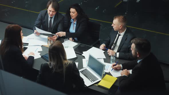 Group of Managers Discussing Progress at Business Meeting