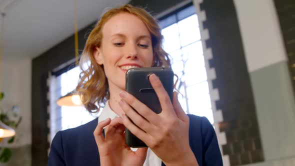 Female executive smiling while using mobile phone 4k