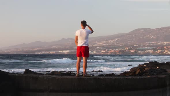 Person looking around with strong waves in the background, Tenerife