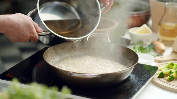 Crop woman cooking risotto in pan in kitchen