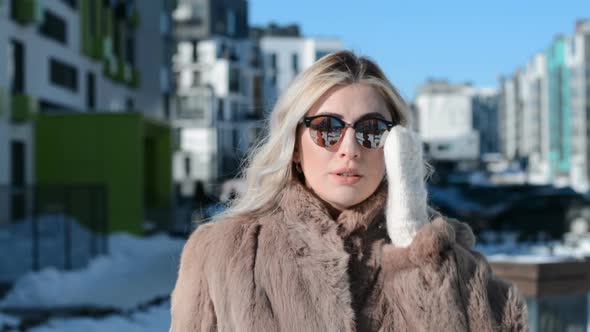 Beautiful Blonde Girl in Sun Glasses Portrait in Winter on the Street