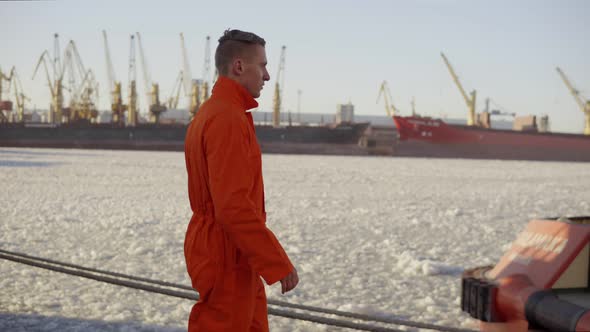 Dock Worker in Orange Uniform Walking in the Harbor and Controlling Working Process in the Port