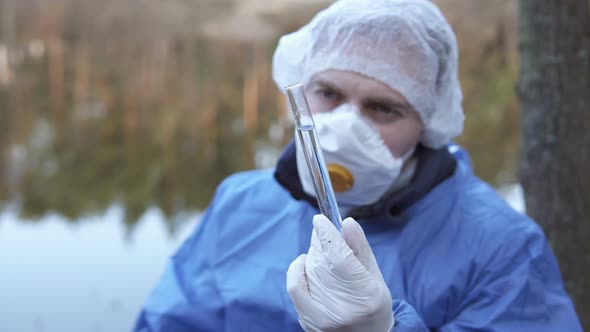 A biologist takes water samples from the river for laboratory research.