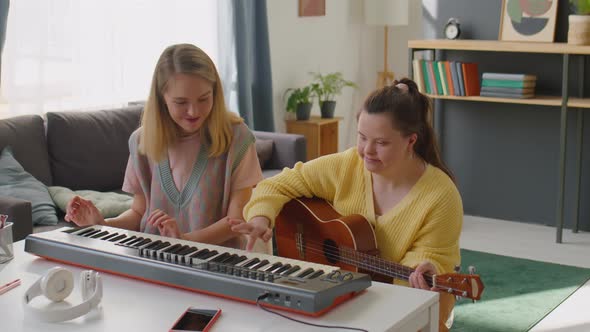 Girl with Down Syndrome Learning Musical Instrument with Teacher