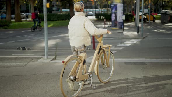 Woman with Wooden Bicycle Crossing Street